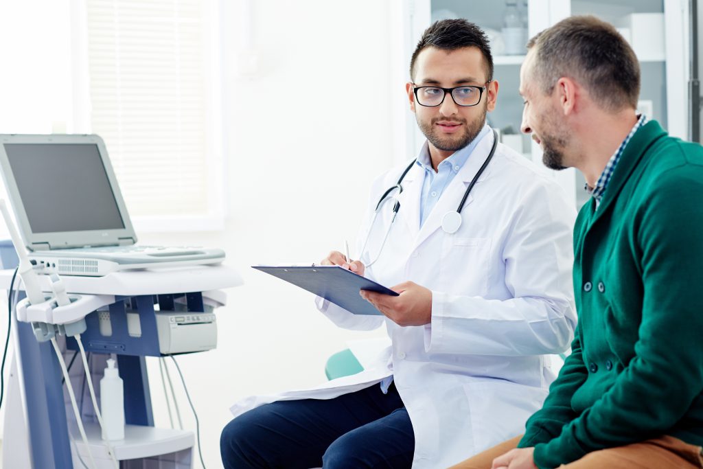 Doctor speaking to man during an appointment